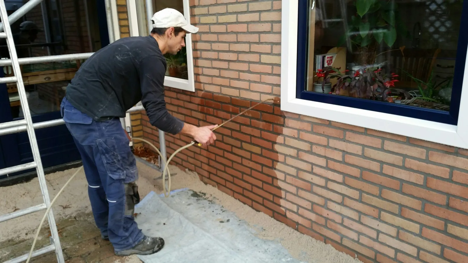 Vakman van Van den Bogaart impregneert een bakstenen gevel